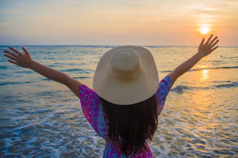 Image of a woman celebrating the sunrise at Bethany Beach