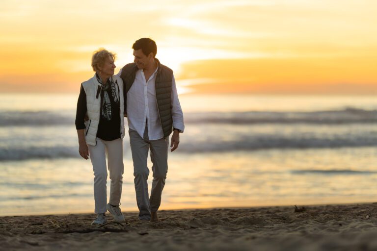 mom and son walking on bethany beach near their luxury home